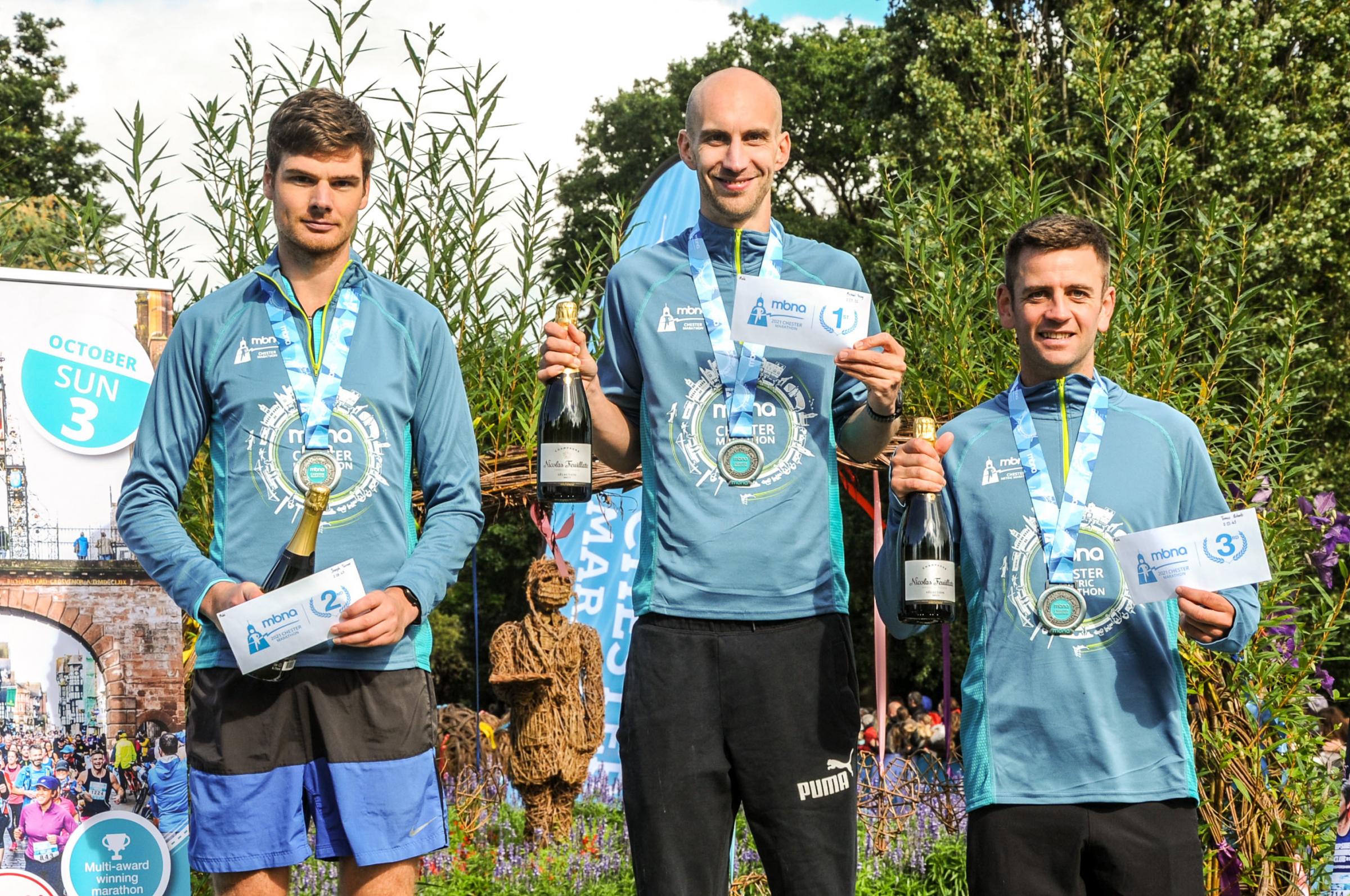 Chester Racecourse start and finish Grosvenor Park, Mbna Chester Marathon, Metric and Mini Marathon. Picture Centre first place man Michael Young, second place Joseph Turner and third place Tomos Roberts. SW03102021.