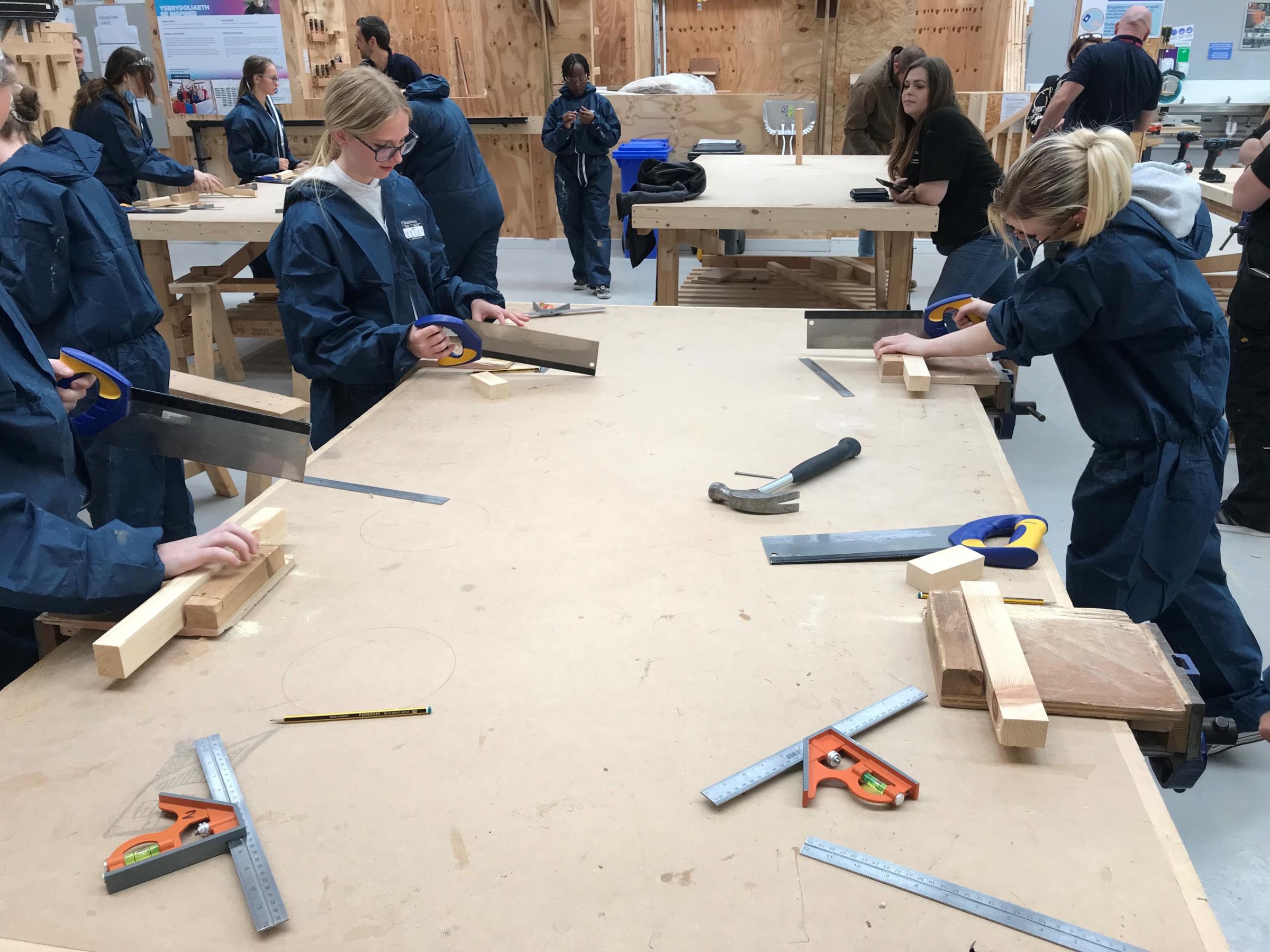 In joinery, the students used hand tools to practice cutting wood to length accurately and join different pieces of wood together.