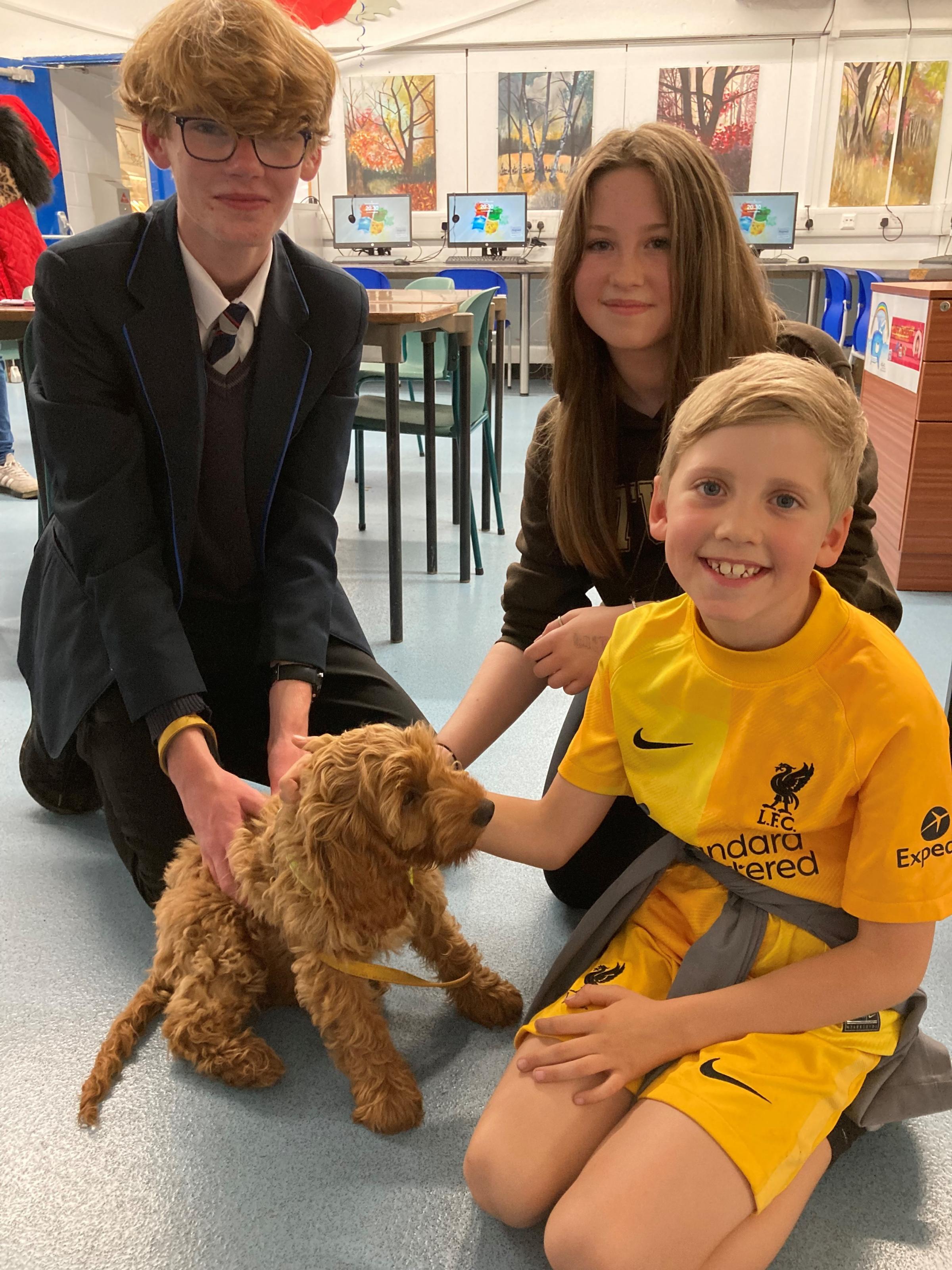 Islay, the wellbeing dog, and Harry Topley, Year 11, with Lily Meeke-Smith and Henri Meeke Smith.