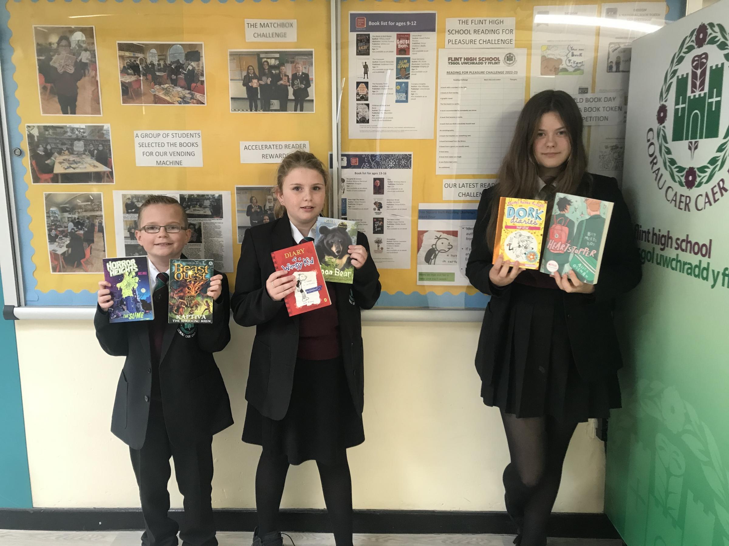 Three Flint High Year 7 students with their new books, from left: Kian Francis, Seren Thompson, and Amelija Gusarova.