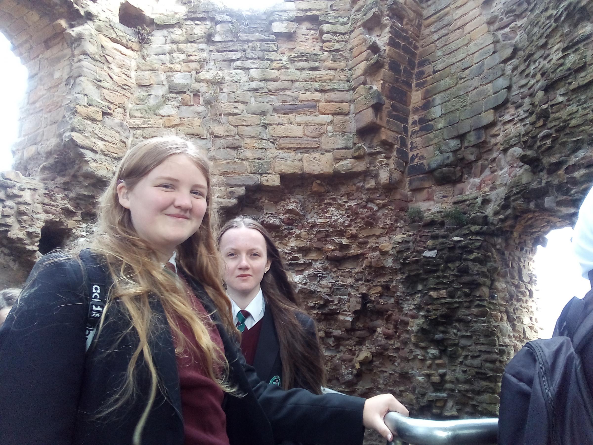 Elizabeth Young and Chloe Ecob search Flint Castle for the initials of ancient stonemasons.