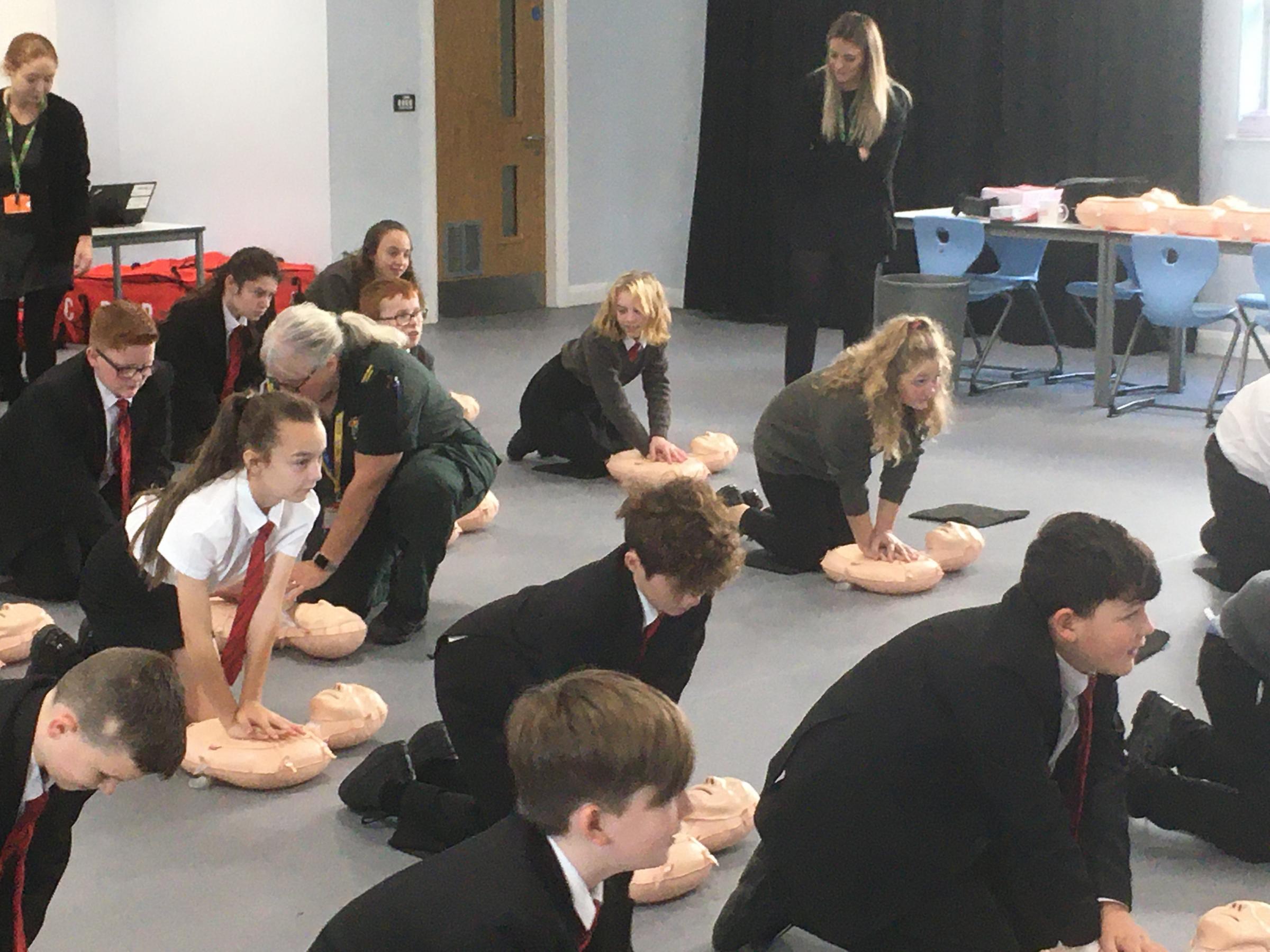 Students practice their CPR skills on dummies.