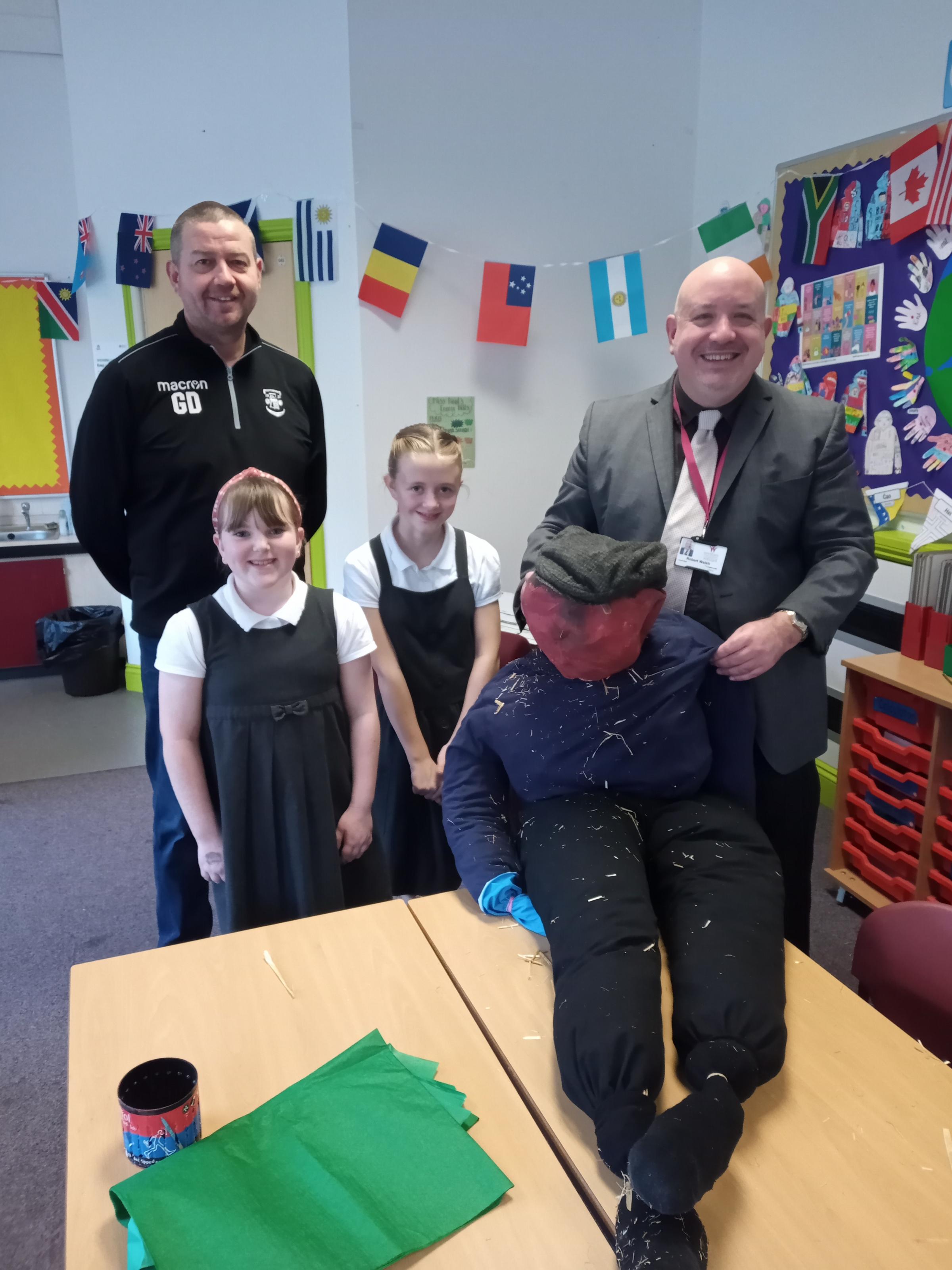 Gavin Davies, from Llay Welfare Football Club and Cllr Rob Walsh, collect the Bonfire Night Guy from pupils at Park CP School.