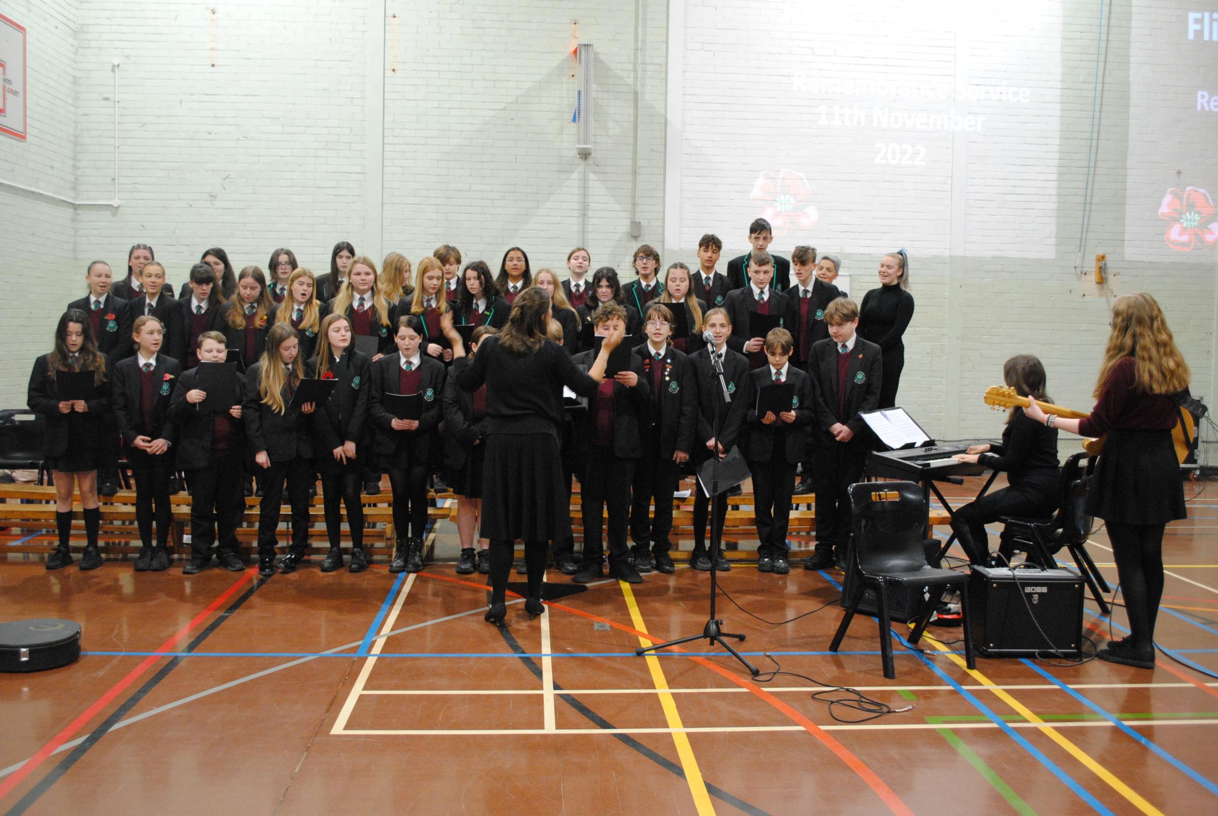 The school choir perform as students assemble for the service.