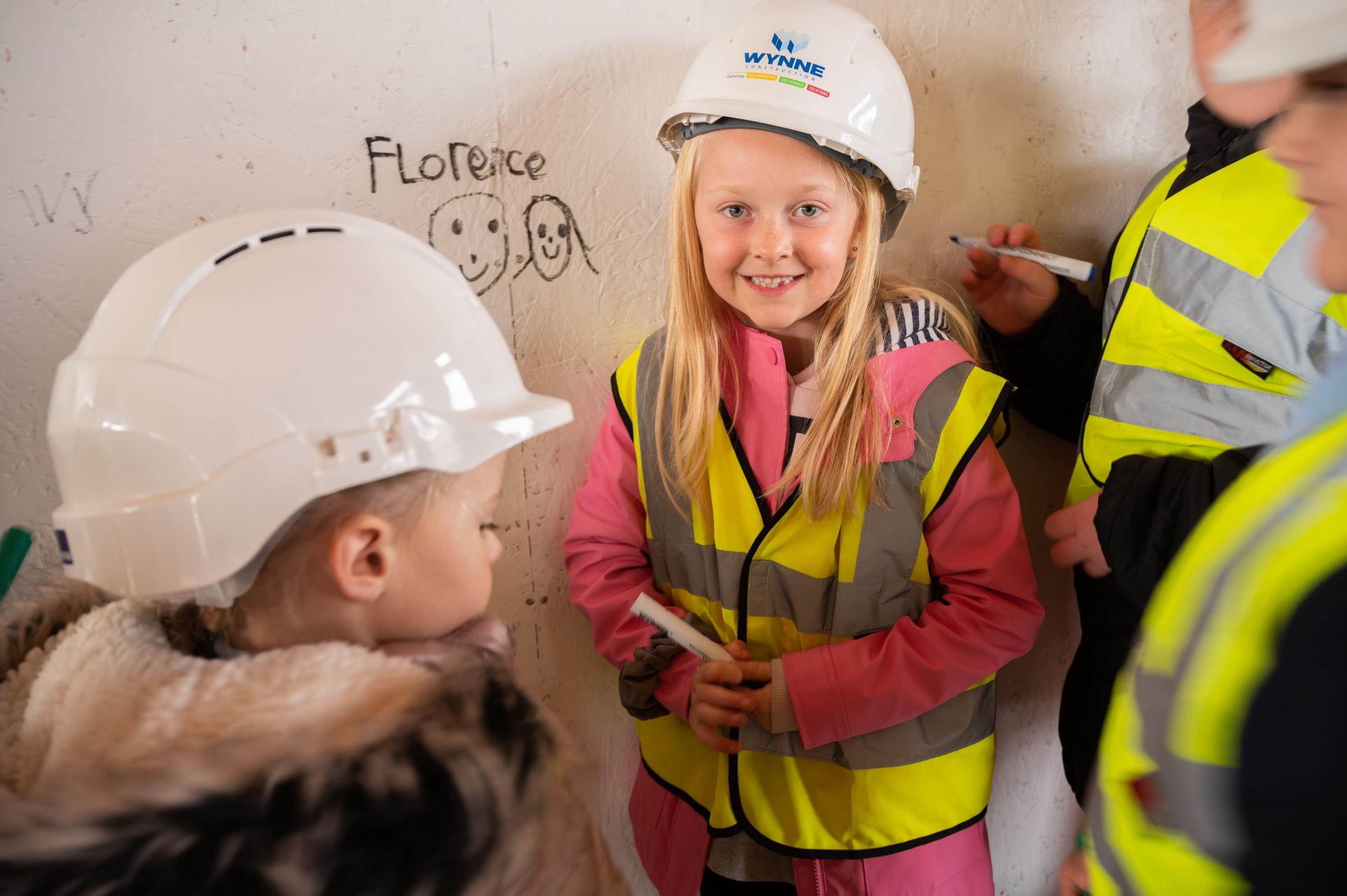 Pupils from Ysgol Yr Hafod sign their name into history during the SIP signing ceremony held by Wynne Construction during a tour of the development.