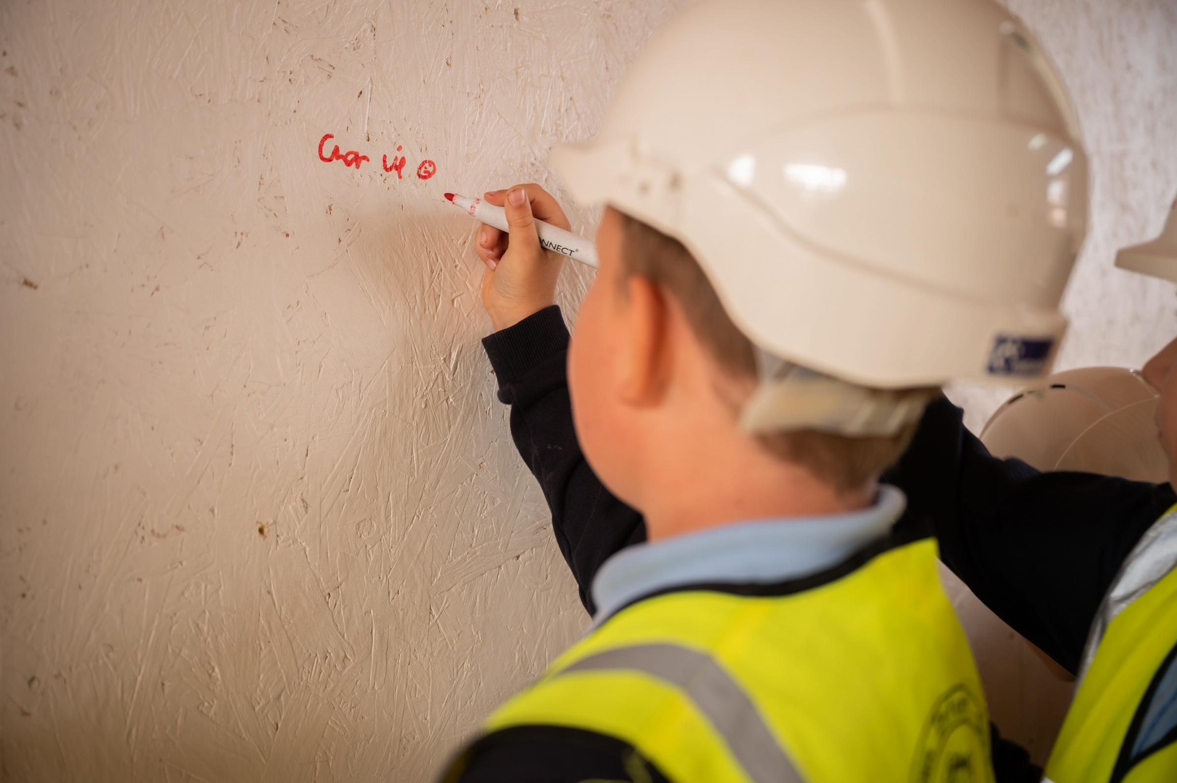 Pupils from Ysgol Yr Hafod sign their name into history during the SIP signing ceremony held by Wynne Construction during a tour of the development.