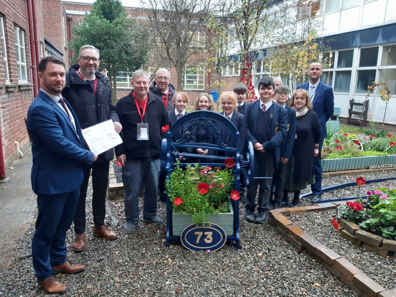 Elfed High School headteacher Alistair Stubbs and Garden Project members Libby Allit, Joshua Robinson, Abbie Lawton, Illiam Pendlebury, Dan Smith, Lowry Jones and Lilly Julian, receive a donation from members of the Buckley Freemasons.