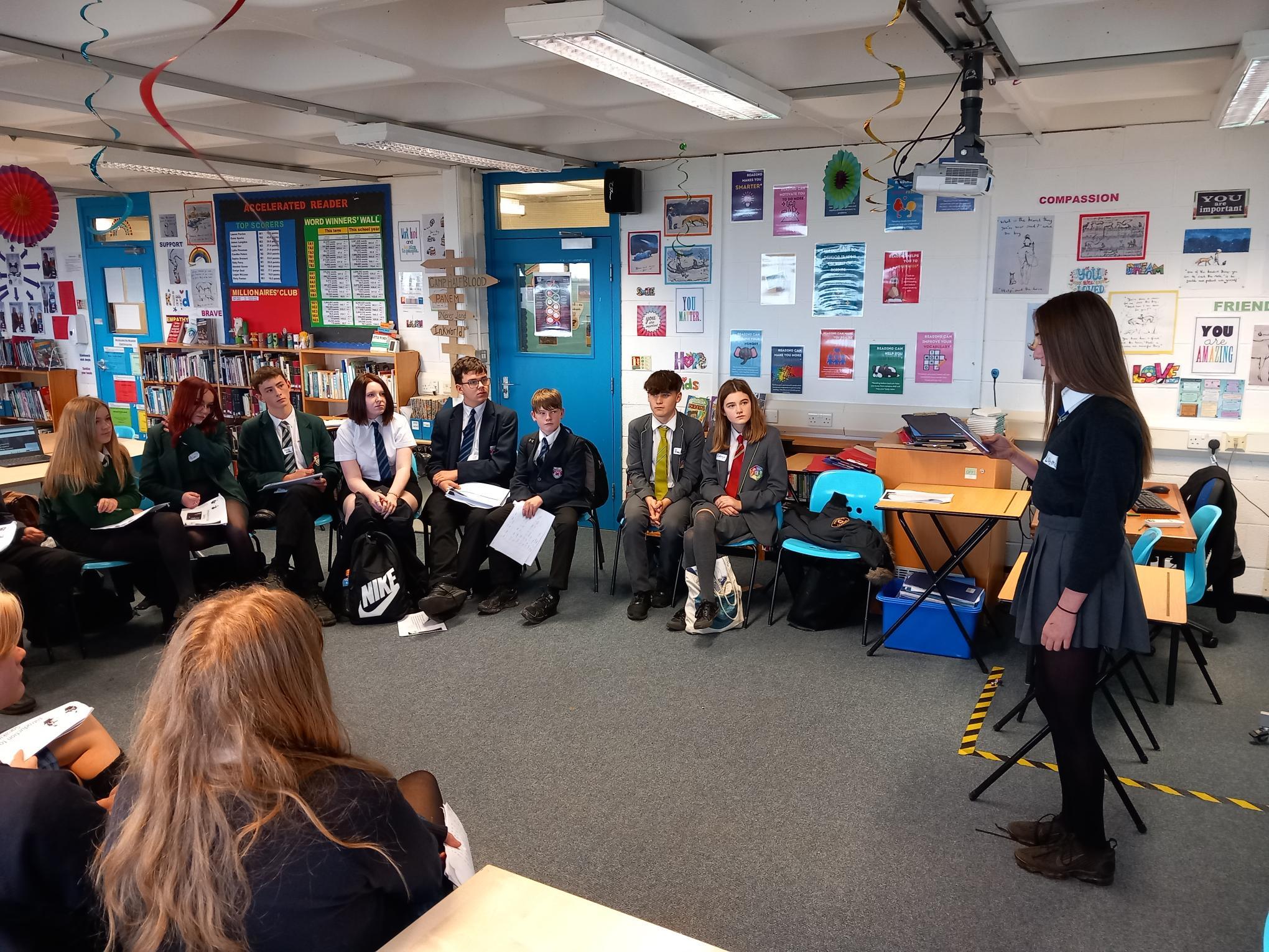 Students practice their public speaking skills in front of each other.