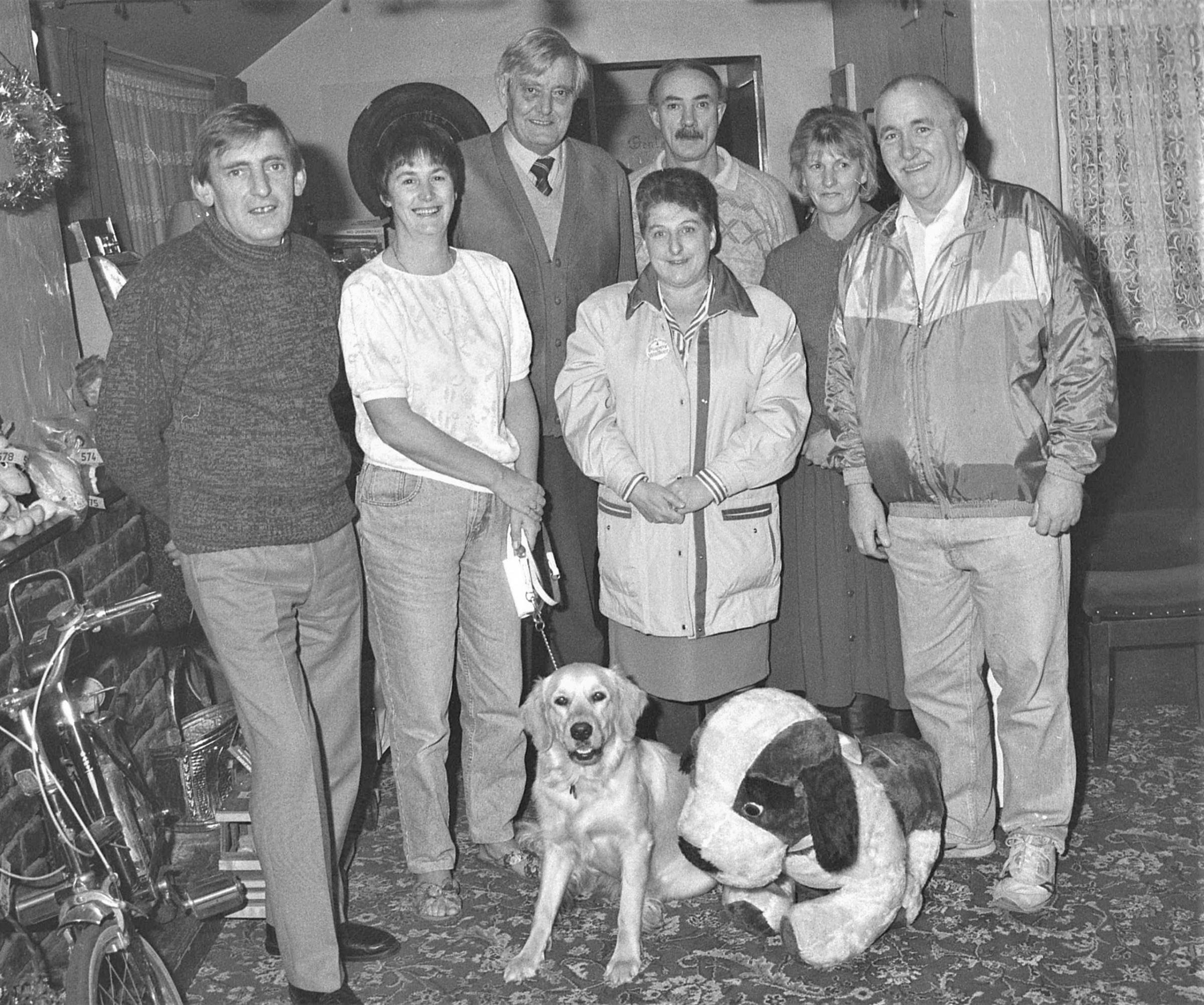 The Bluebell in Buckley held an auction of donated gifts in aid of Guide Dogs for the Blind. Pictured with puppy Nikki are Malcolm Cross, landlady Thelma Gatrell, John Bell, Margaret Black, Robin Gillam, Mair Gillam and Ron Kaberry, December 1991.