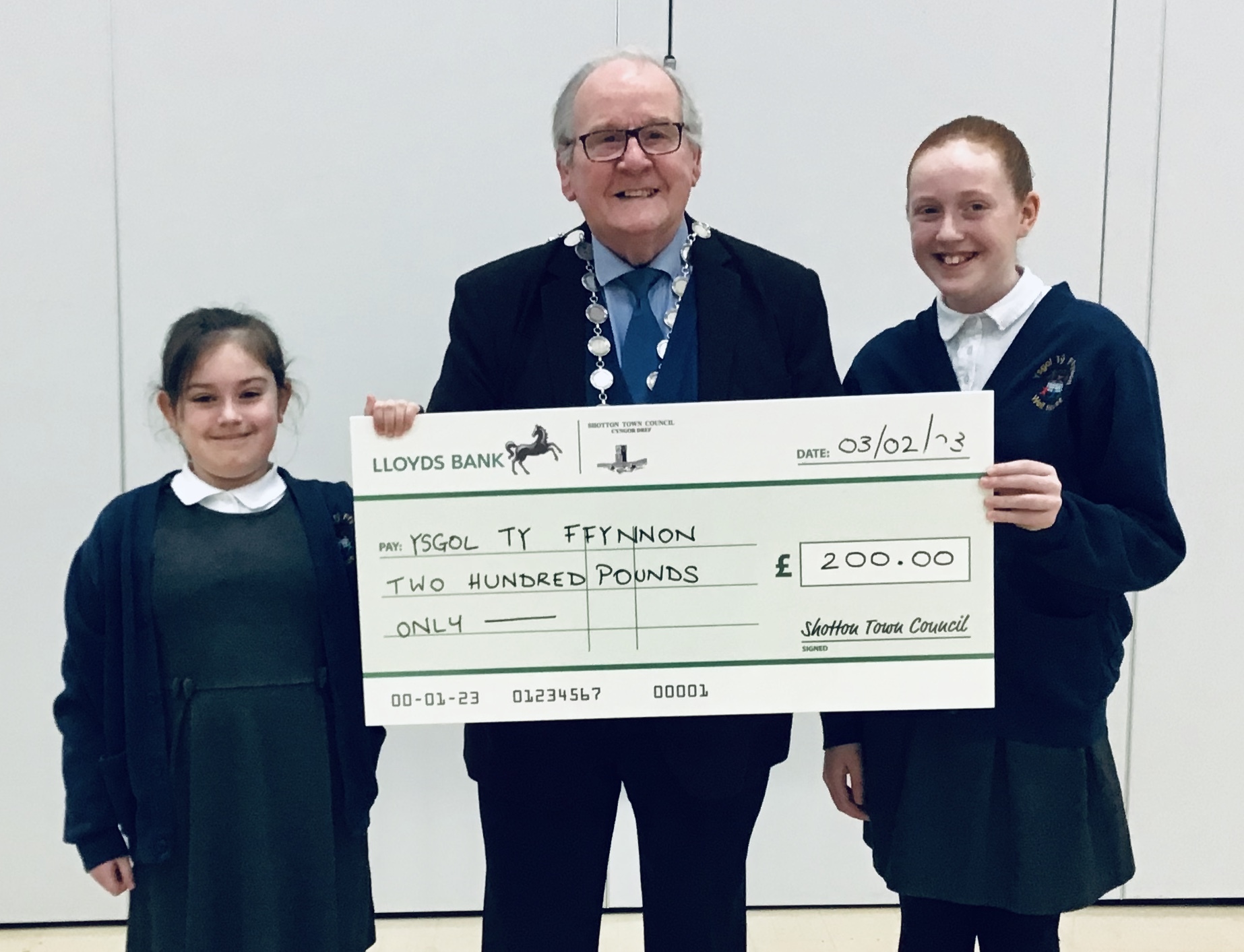 Ty Ffynnon School Councils Holly and Ava accept a donation from Cllr Gary Cooper, by Shotton Town Council.