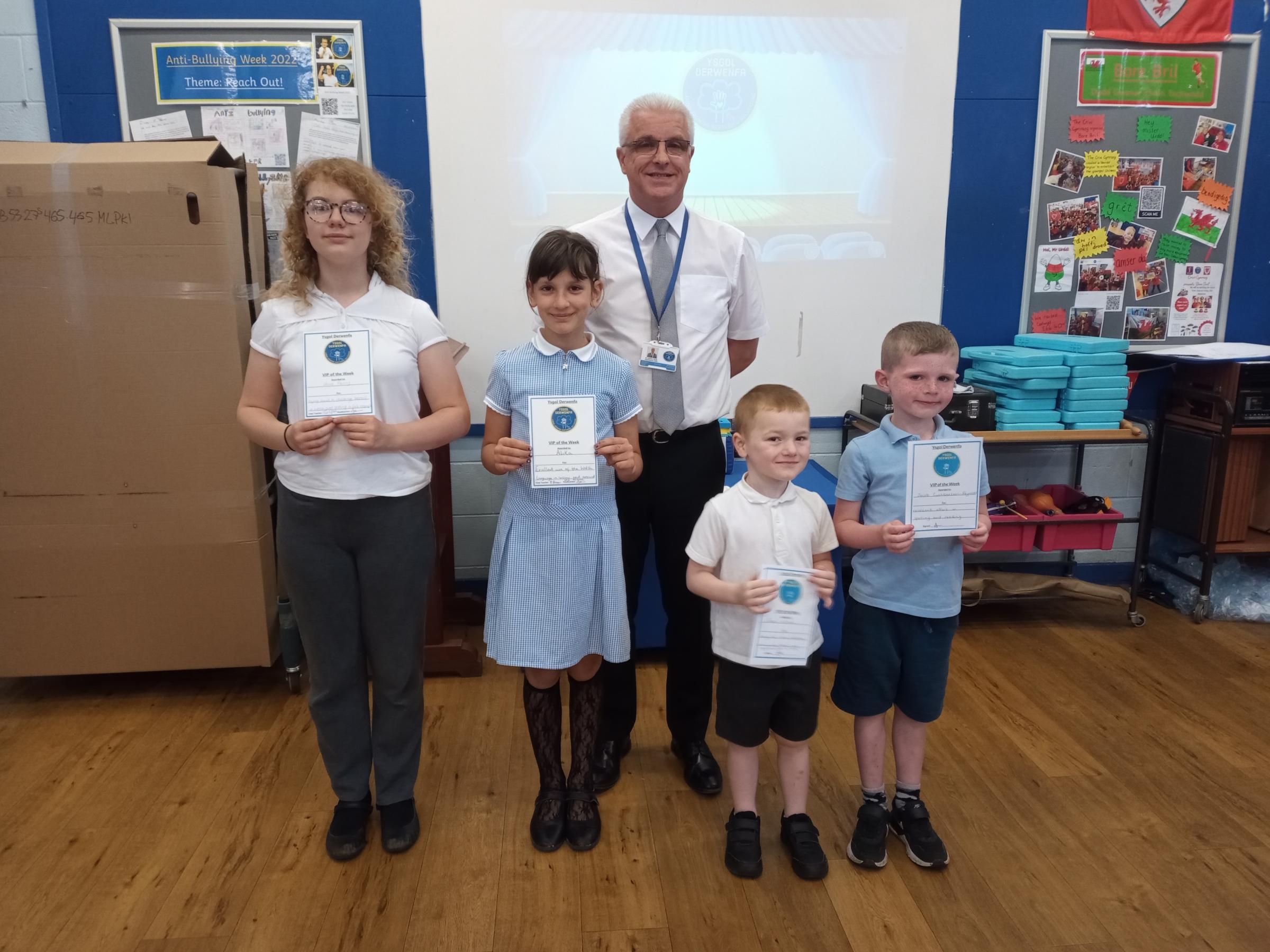 Headteacher Andy Jones with Ysgol Derwenfas VIPs of the Week, Jacob Williams, Jacob Cuthbertson-Reynolds, Alika Burkovska and Yeva Parry.