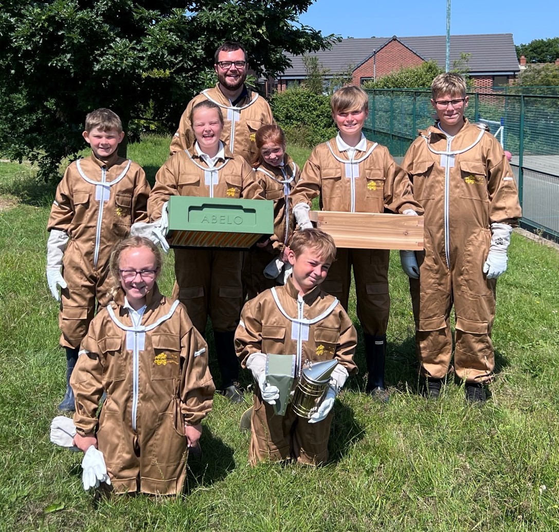 Assistant headteacher Andrew Sutton with young beekeepers at Ysgol Bryn Garth.