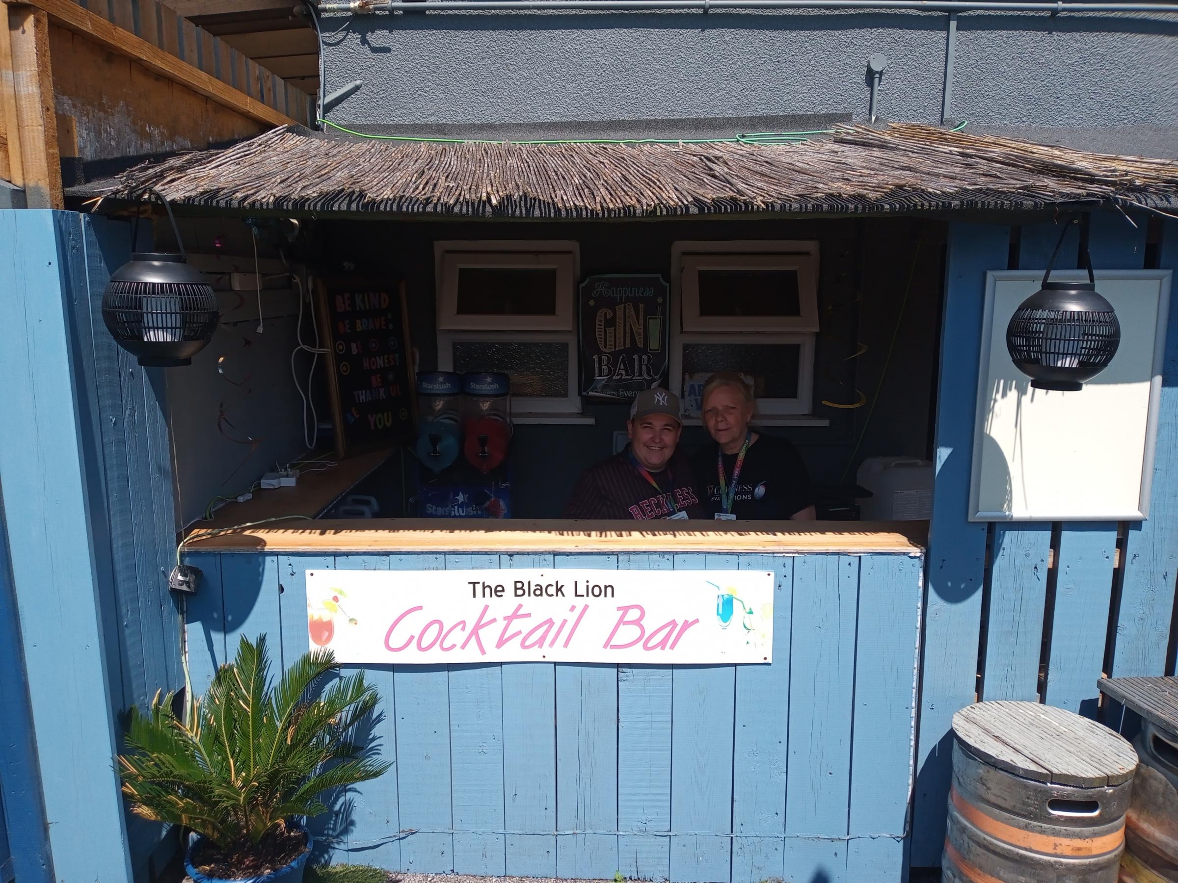 Chlsea Hibbery and Denise Rose behind the cocktail bar in the beer garden at the Black Lion in Buckley.