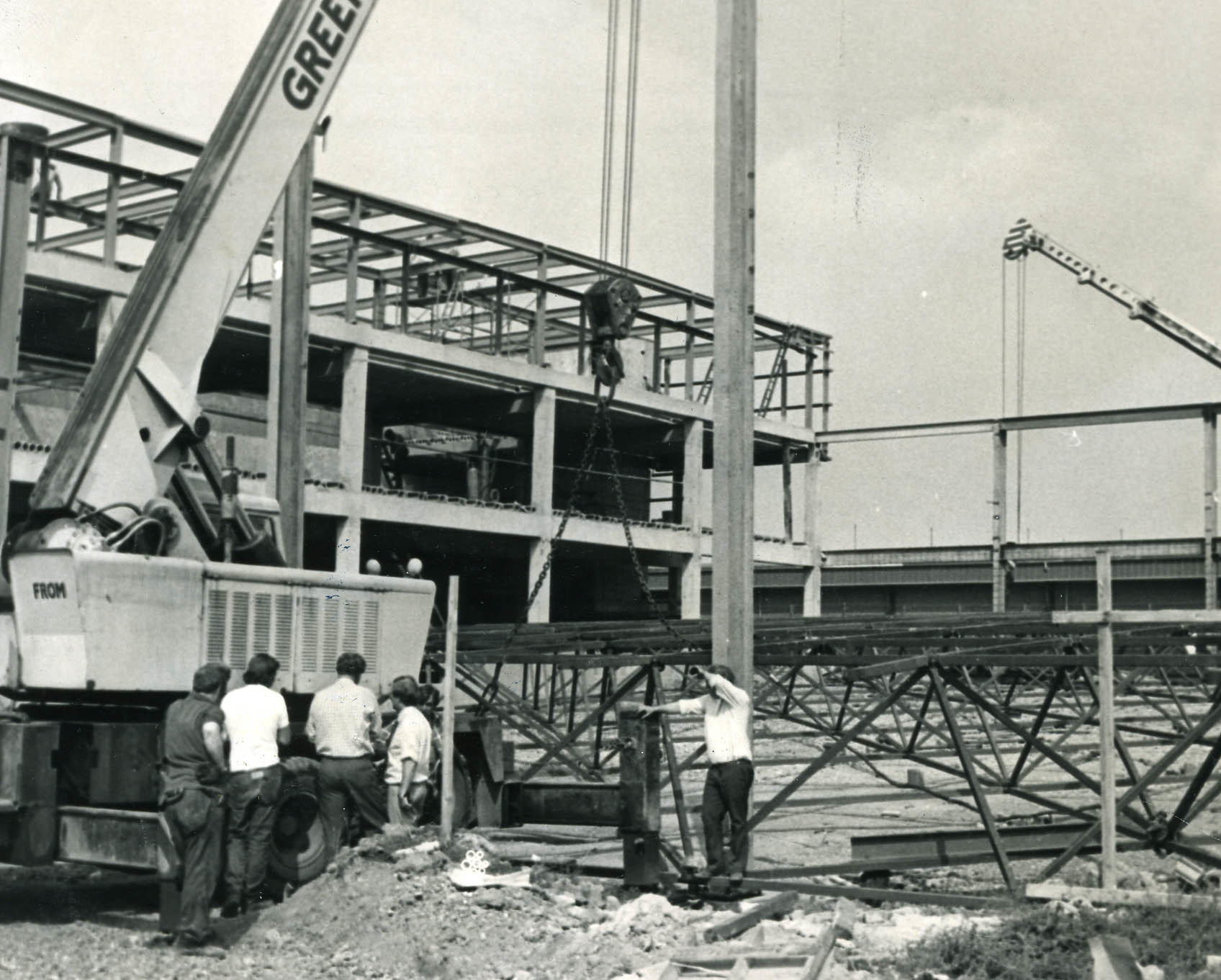 Crane side conference at the site of Phase Two of the Plas Madoc Leisure Centre, as they attempted to raise the section roof, 1975.