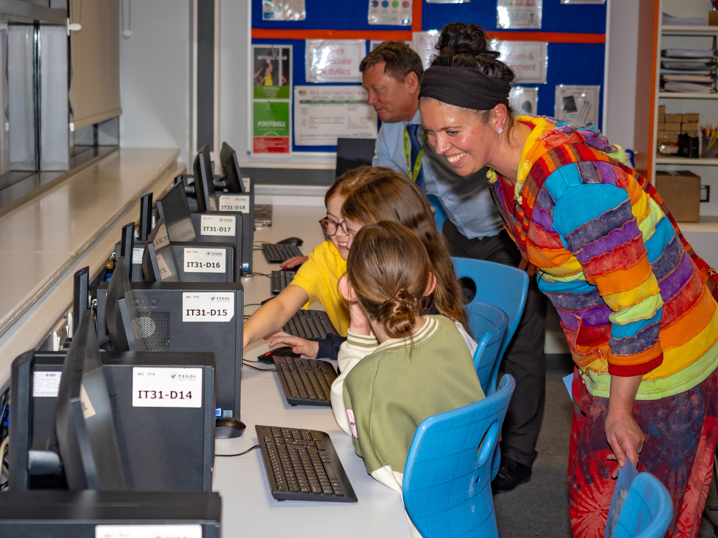 Young visitors explore computer-based activities in ICT and business.