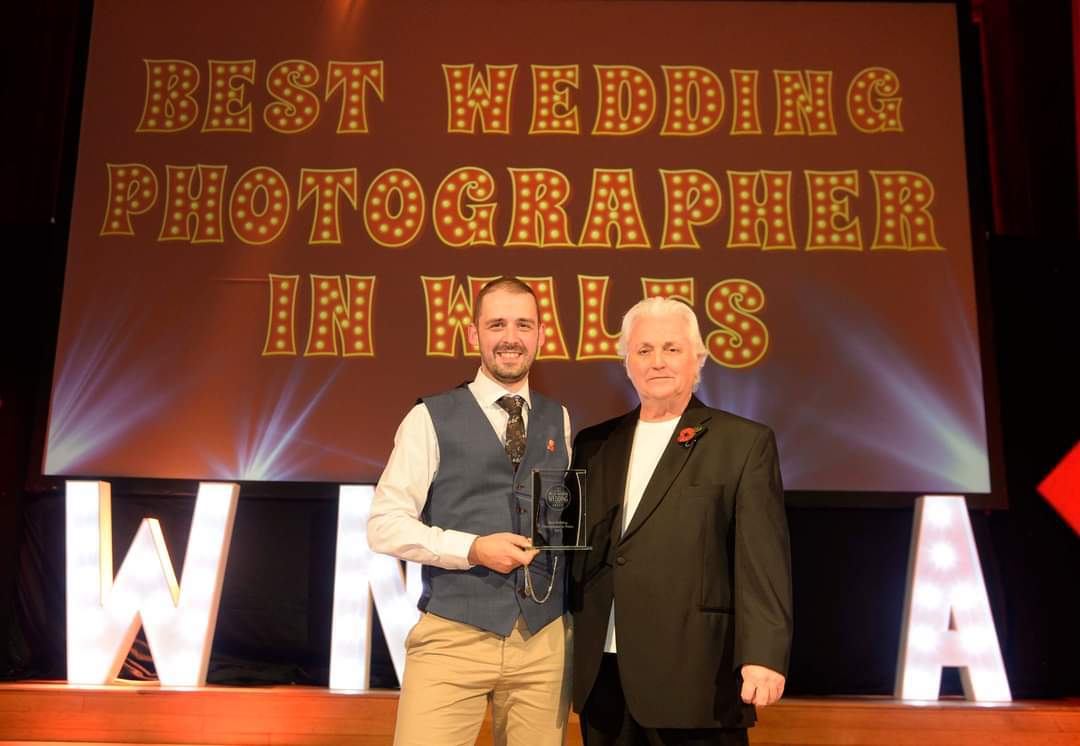 Richard Miller collects his Best Wedding Photographer in Wales award from David Emanuel.