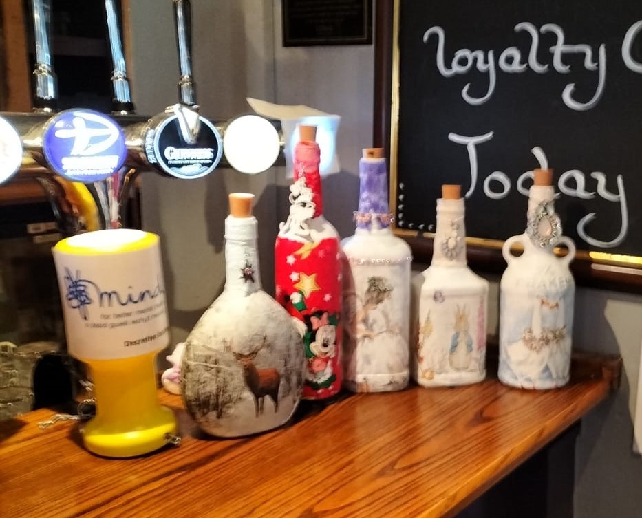 Some of Elaine Hughes decoupage bottles, made and sold for charity.