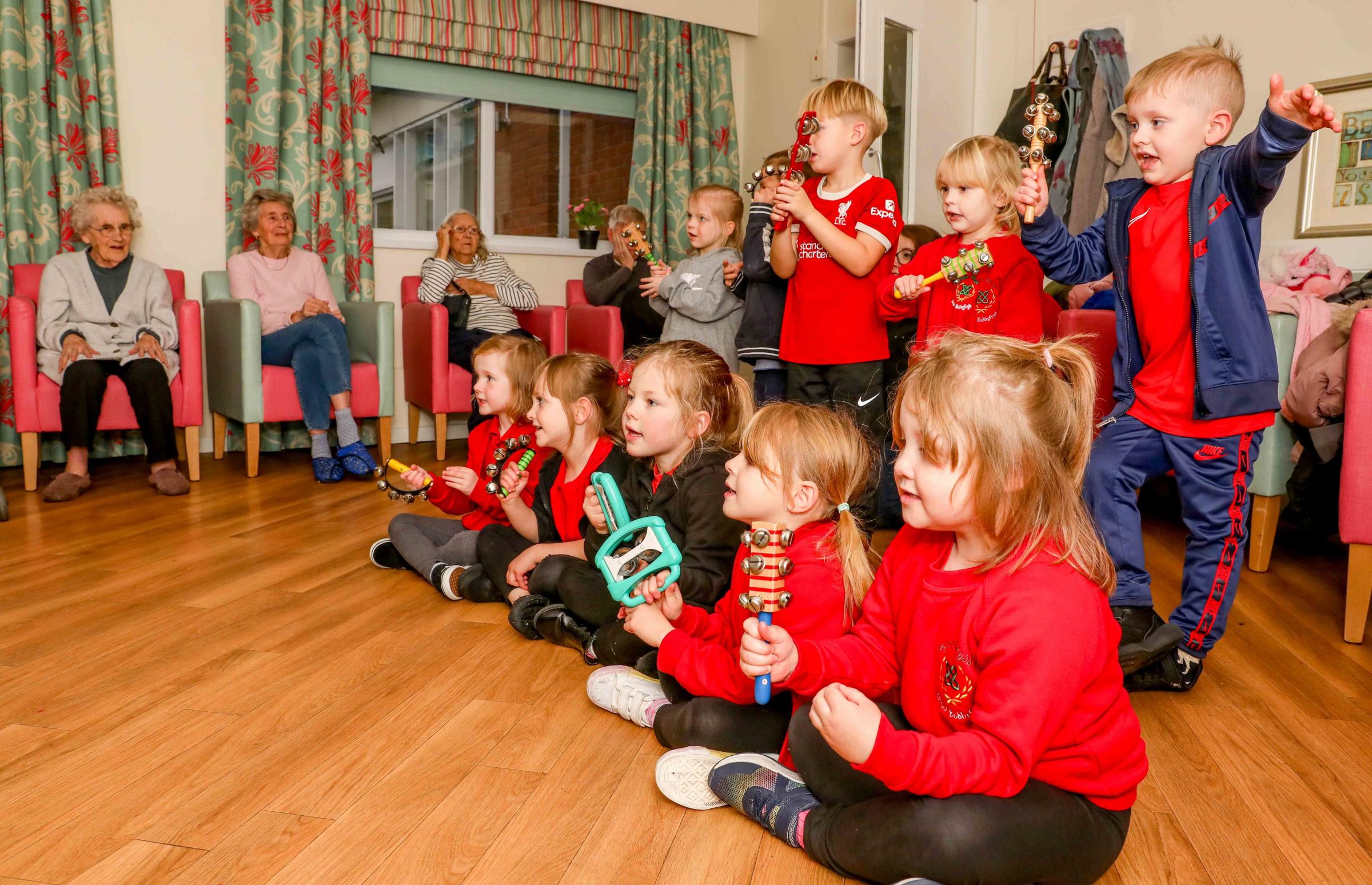 Ysgol Bodhyfryd reception class pupils sing with Pendine Hillbury Care Home residents.