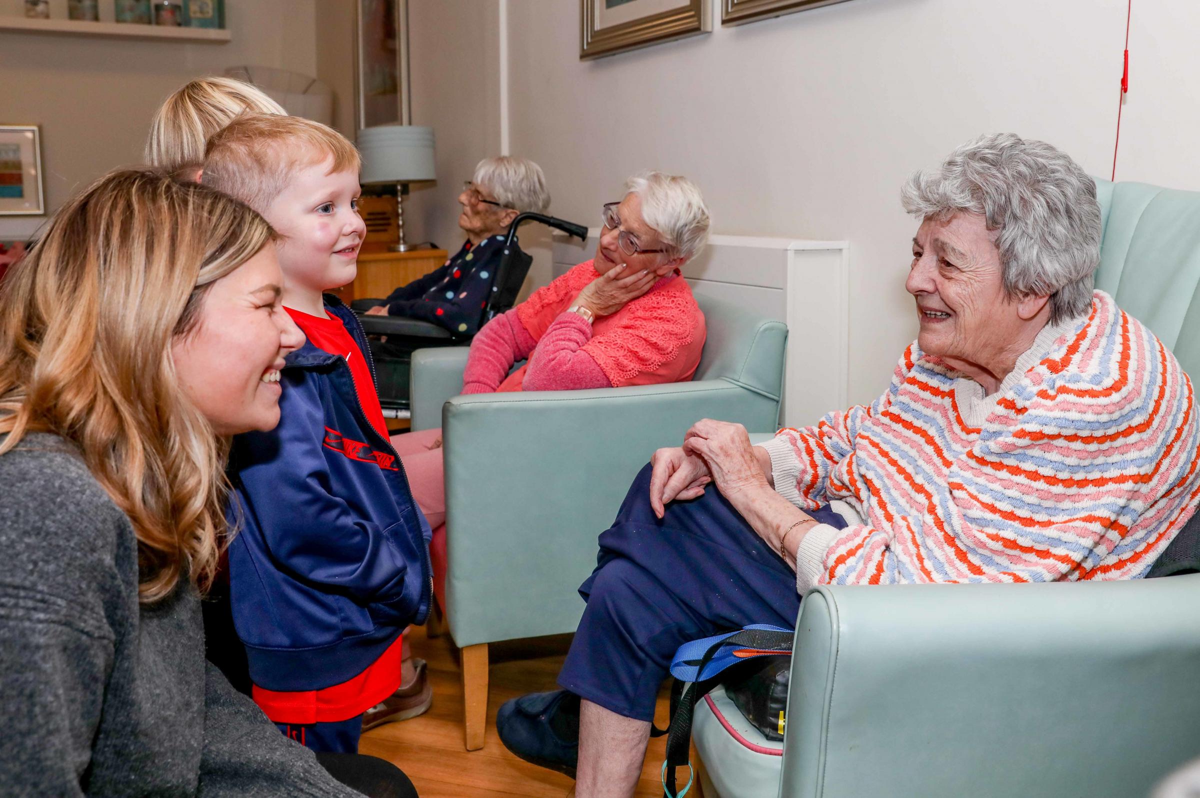 Teacher Ellen OSullivan joins pupils in chatting with Sylvia Williams.