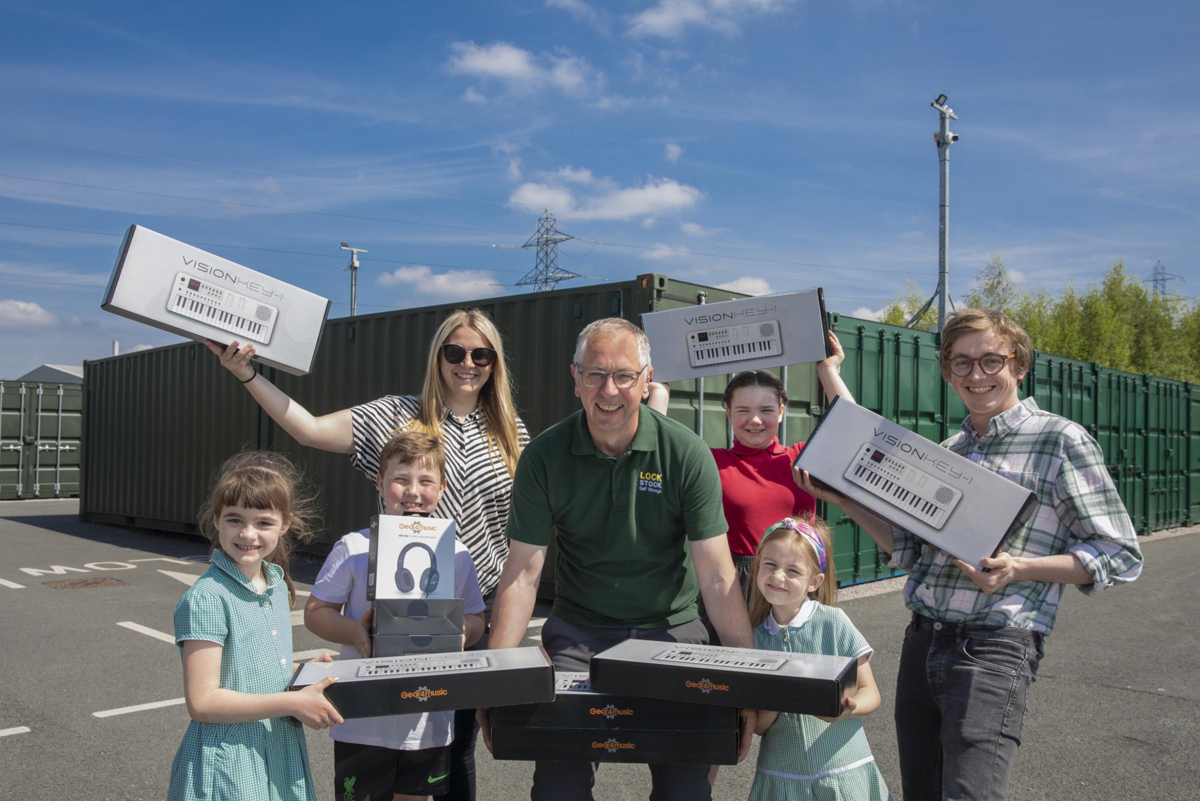 Pupils at Sandycroft Primary School with new keyboards and headphones, courtesy of Lock Stock Self Storage, Daisy, Joseph, Penelope, and Lily-Anne, with teacher Jack Merrick, teaching assistant Hannah Young and Lock Stocks Rob Jones. Photo: Mandy Jones