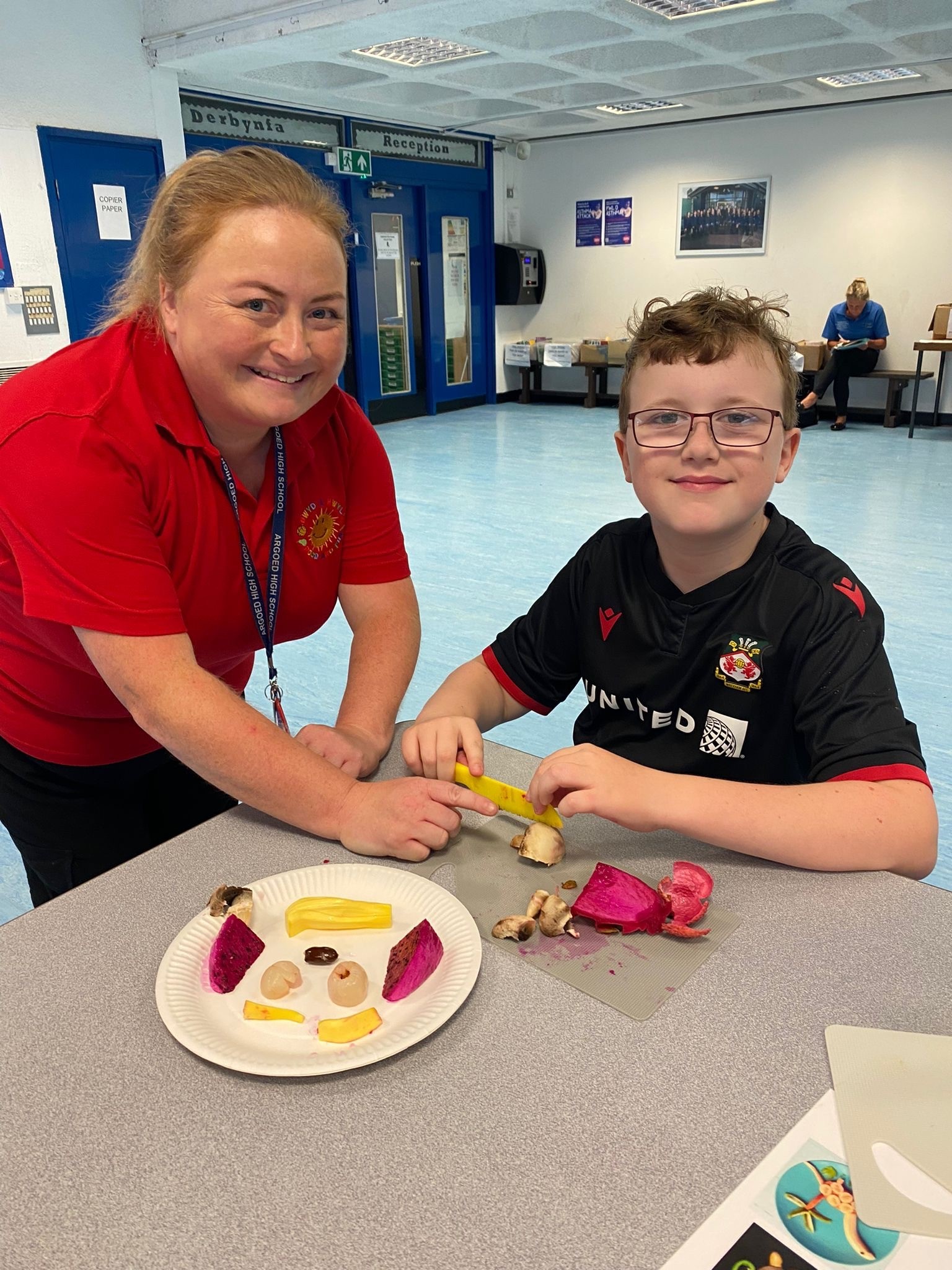 Rachel Boyd, Club Leader, and Logan McCormack, during a fruit art activity with dragon fruit, lychees and jackfruit. The activity helps children gain confidence touching, smelling, and trying different foods.