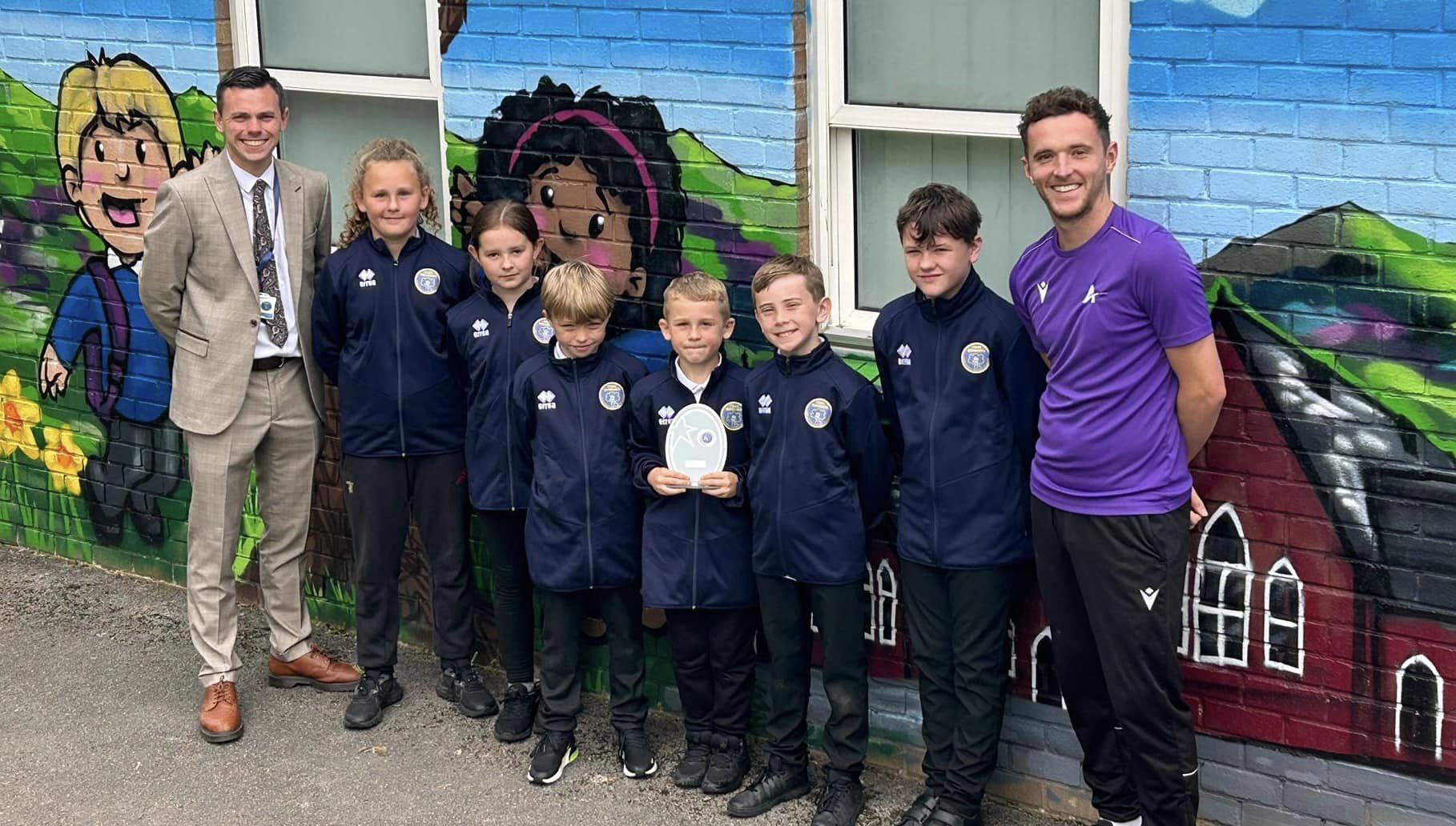 Deputy headteacher John Andrew Jones, with pupils Ava, Libby, TJ, Ethan, Jacob, Harley and Daniel Font from Aura Sports Development.