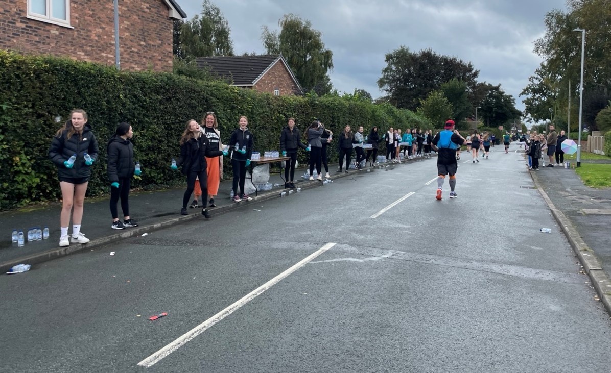 Students from Darland High School run a water station during the Chester Marathon.