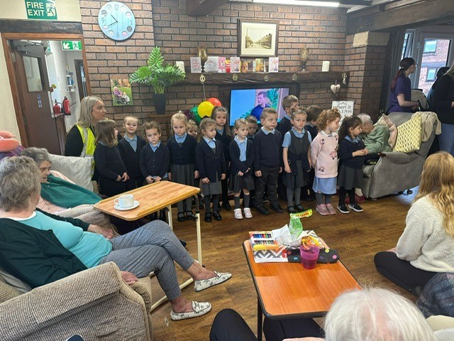 Class 1 pupils from St Ethelwolds Primary, visit residents at Hollybank Care Home.