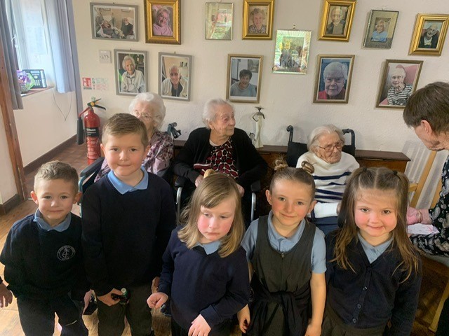 Class 1 pupils from St Ethelwolds Primary, visit residents at Hollybank Care Home.