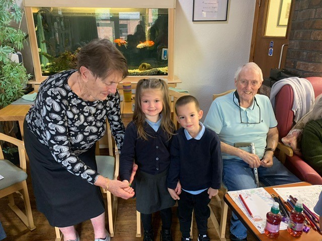 Class 1 pupils from St Ethelwolds Primary, visit residents at Hollybank Care Home.