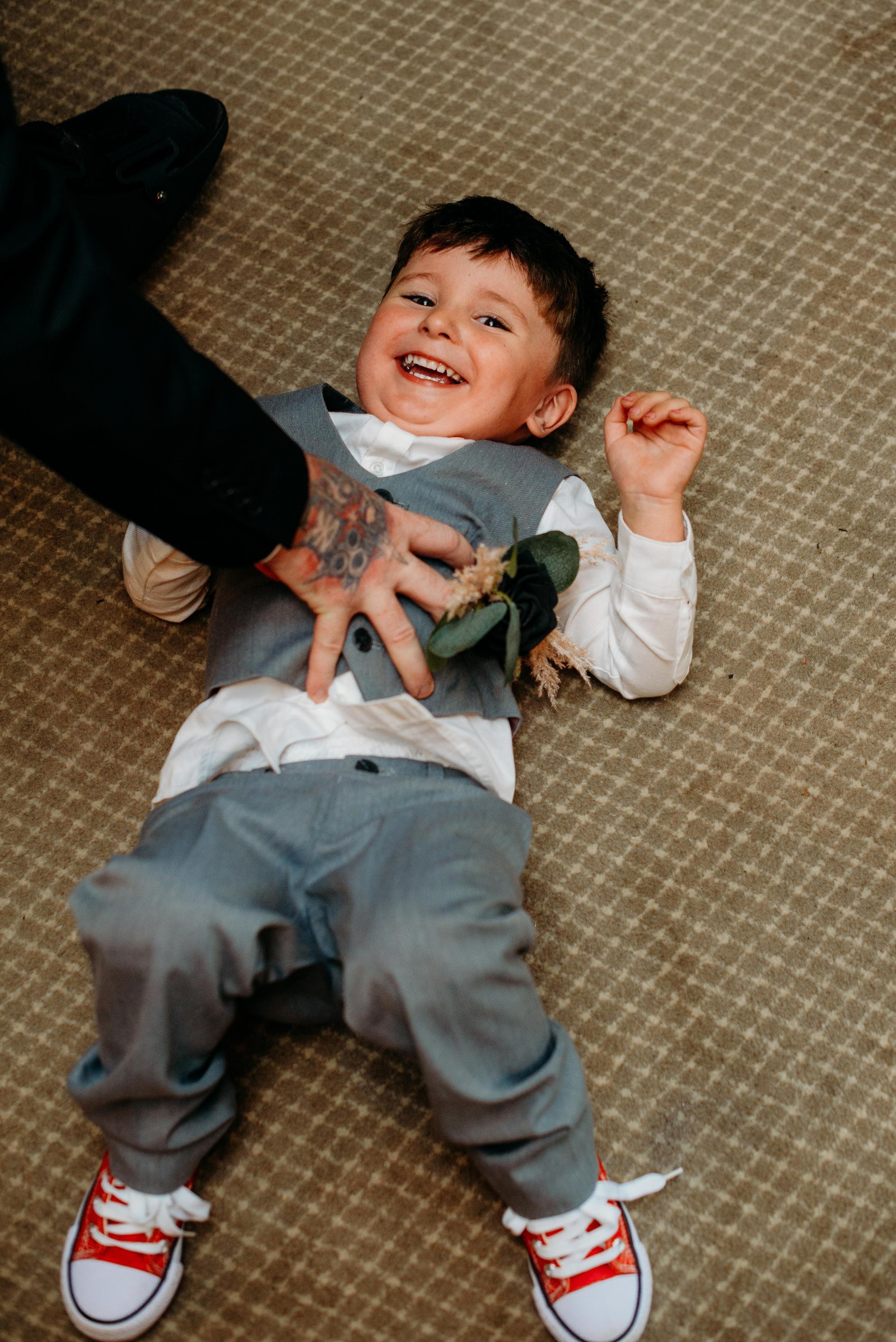 Ring bearer Hayden Solari being tickled by Mathew Pierce.